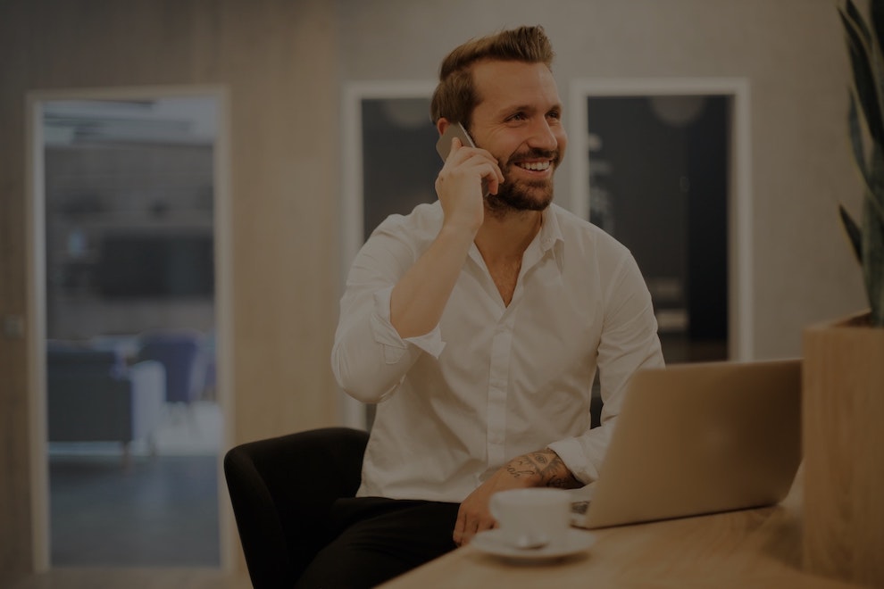 man talking to someone while in front of a laptop